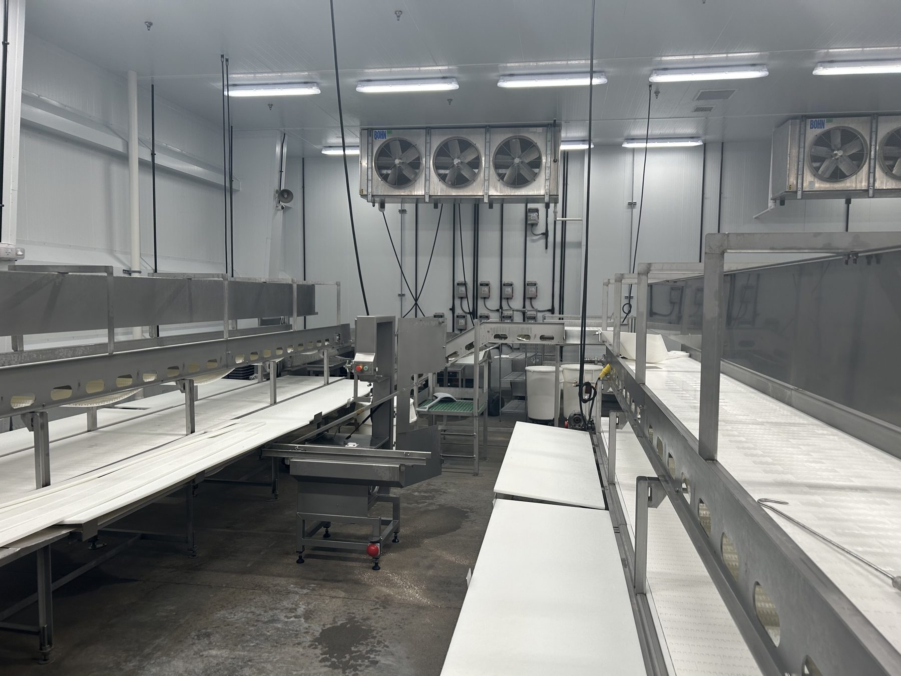 Fabrication room with stainless conveyors and cutting tables
