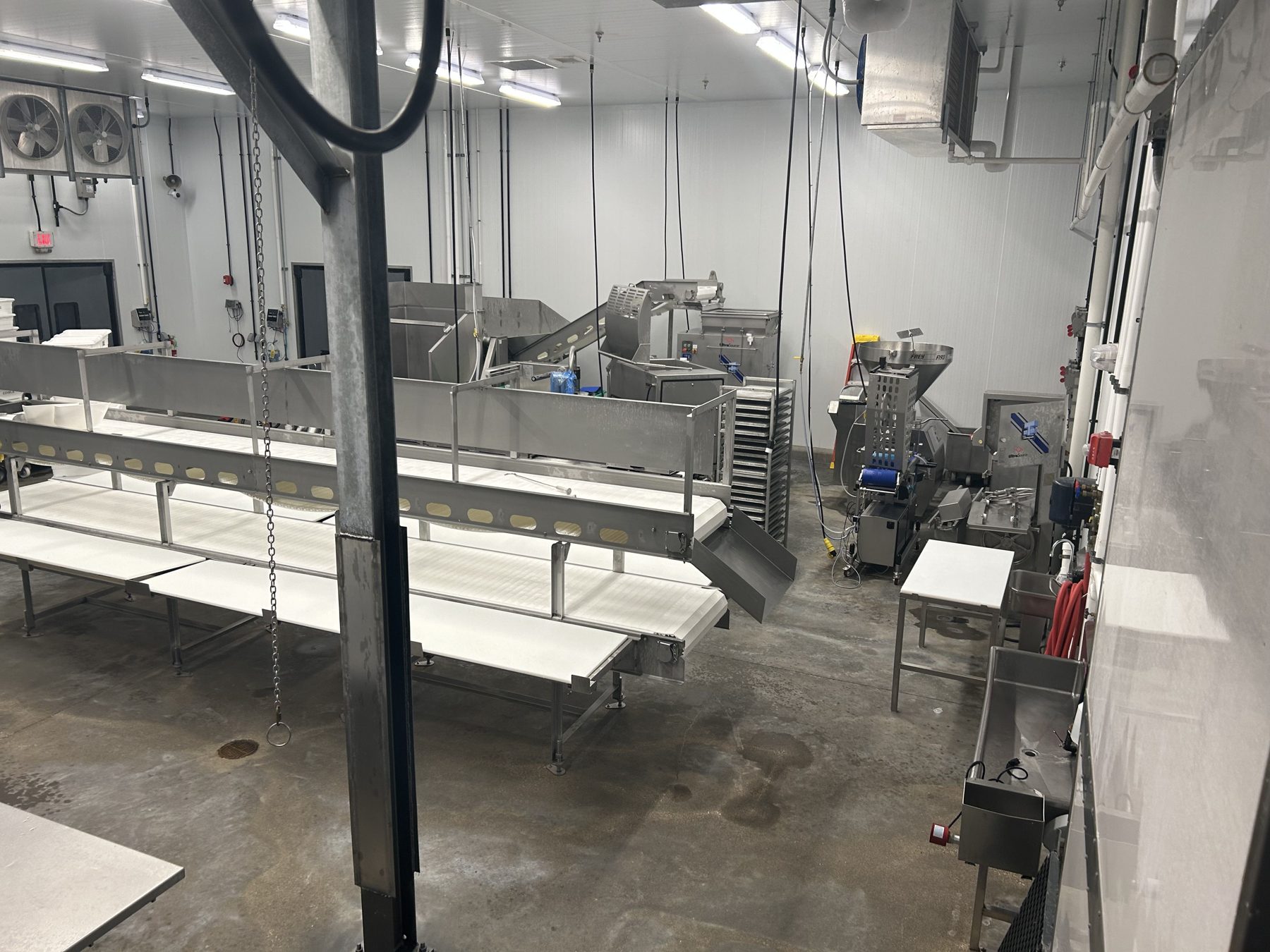 Close view of a stainless cutting station and takeaway belt